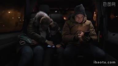 三名乘客在深夜乘坐小巴旅行，母亲和儿子用智能手机娱乐，男子打发时间